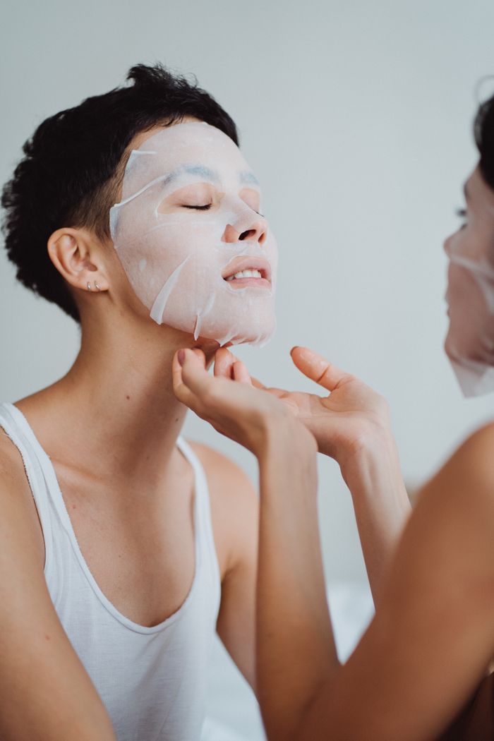Two adults enjoying a relaxing skincare session with nourishing facial masks indoors.